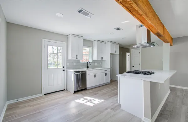 a kitchen with granite countertop a sink stove and refrigerator