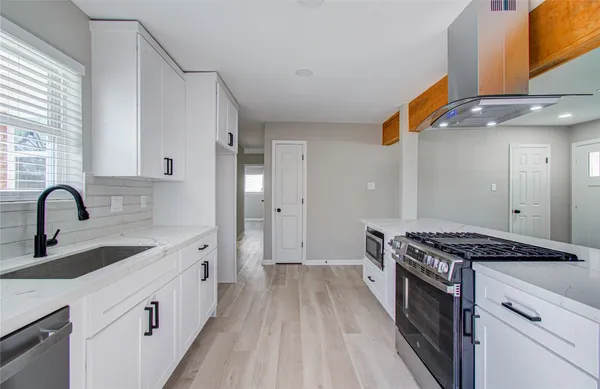 a kitchen with stainless steel appliances granite countertop a sink stove and cabinets