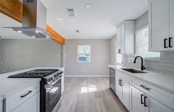 a kitchen with granite countertop a sink stainless steel appliances and cabinets