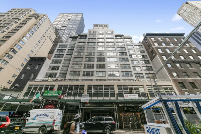 a front view of a building with lot of cars parked