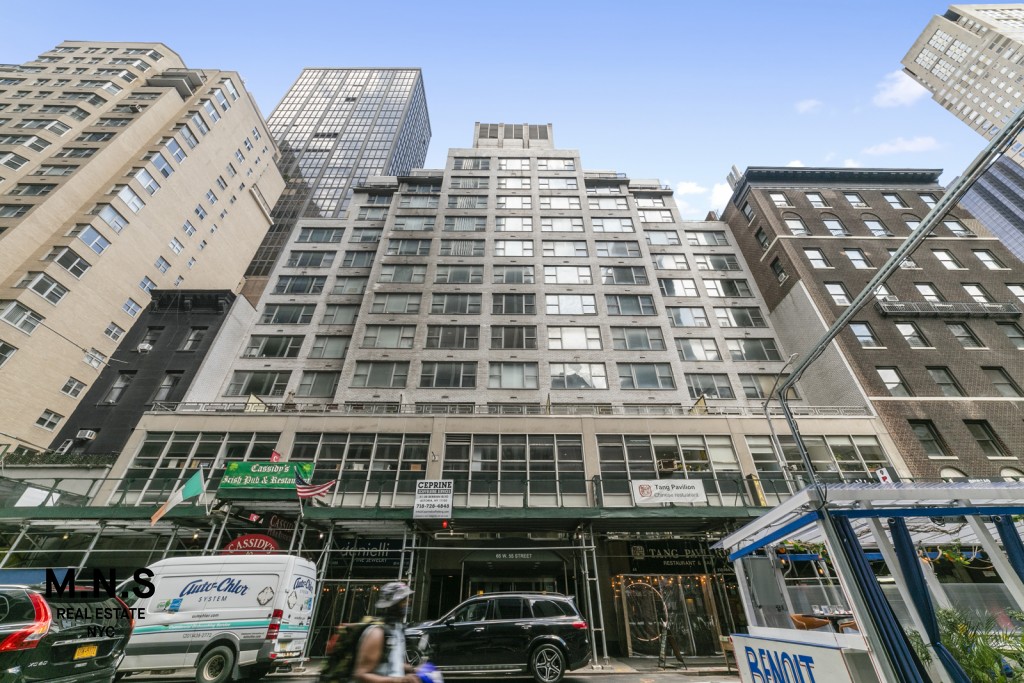 65 West 55th Street, Unit PHRE Manhattan, NY 10019 - Photo 12 of 12 a front view of a building with lot of cars parked
