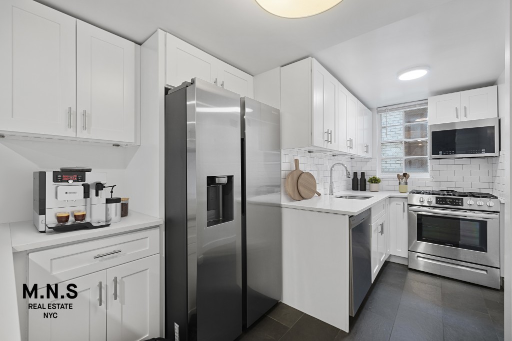 65 West 55th Street, Unit PHRE Manhattan, NY 10019 - Photo 6 of 12 a kitchen with stainless steel appliances a refrigerator sink and microwave