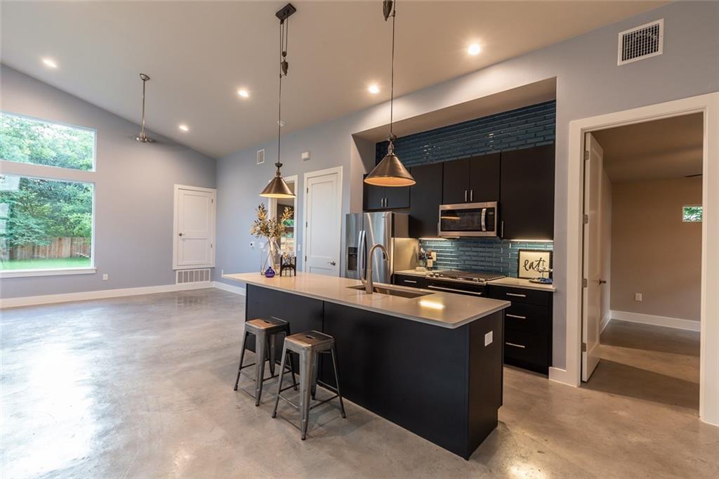 1142 Eleanor Street, Unit 2 Austin, TX 78721 - Photo 5 of 24 A contemporary open-concept kitchen with a substantial island flows seamlessly into the main living area.