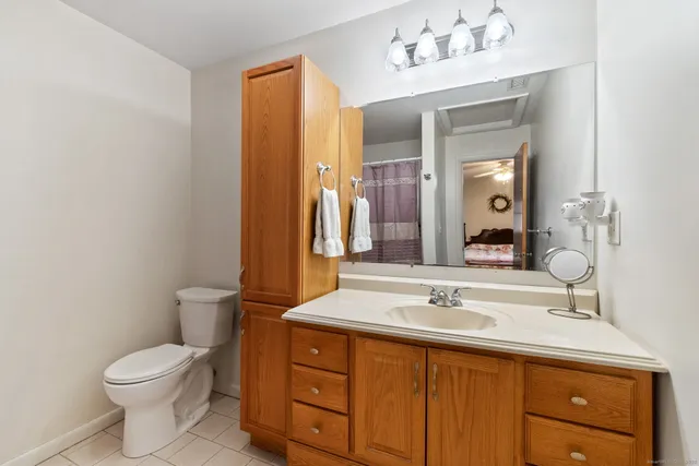 a bathroom with a sink vanity mirror and toilet