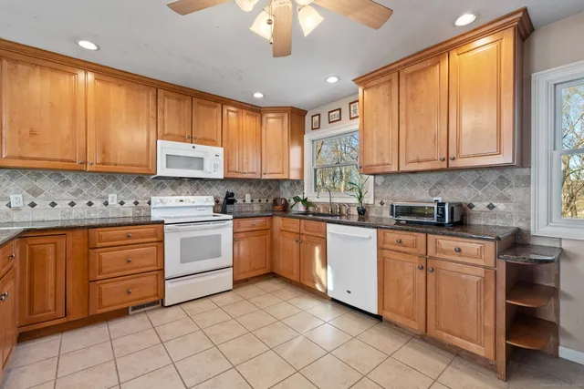 a kitchen with stainless steel appliances granite countertop a sink window and cabinets