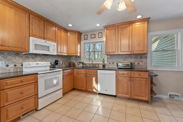 a kitchen with granite countertop cabinets stainless steel appliances a sink and counter space