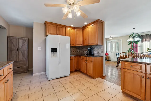 a kitchen with stainless steel appliances granite countertop a refrigerator and a stove top oven