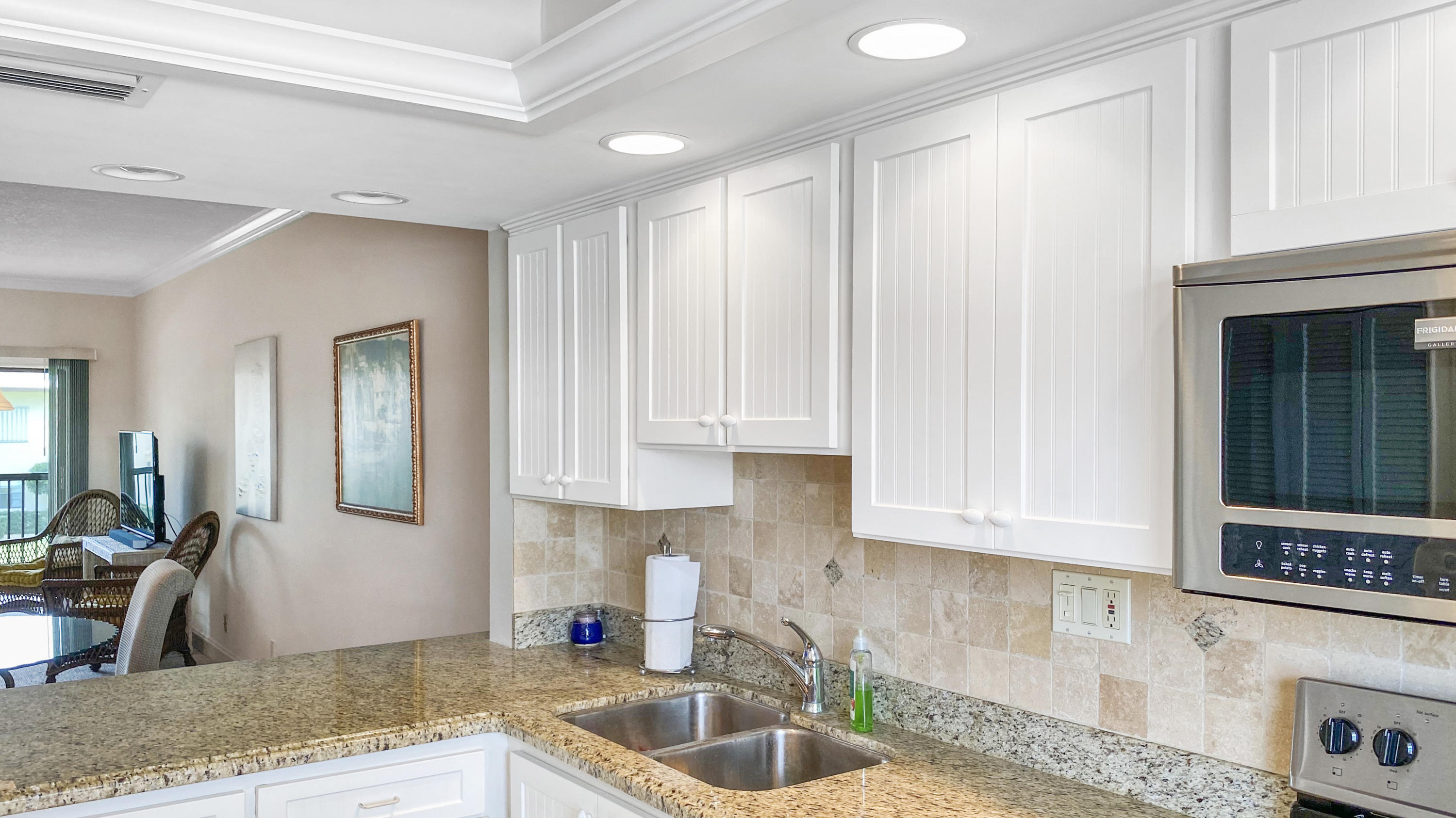275 South Beach Road, Unit B202 Jupiter, FL 33469 - Photo 11 of 25 a kitchen with granite countertop a sink a stove and cabinets