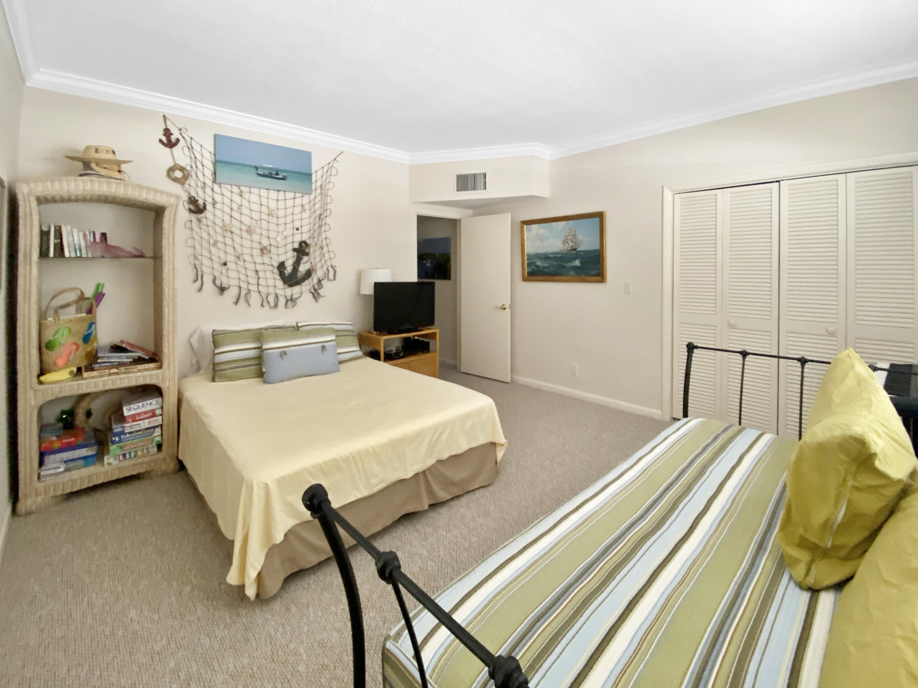 275 South Beach Road, Unit B202 Jupiter, FL 33469 - Photo 19 of 25 a bedroom with a bed and a table in it