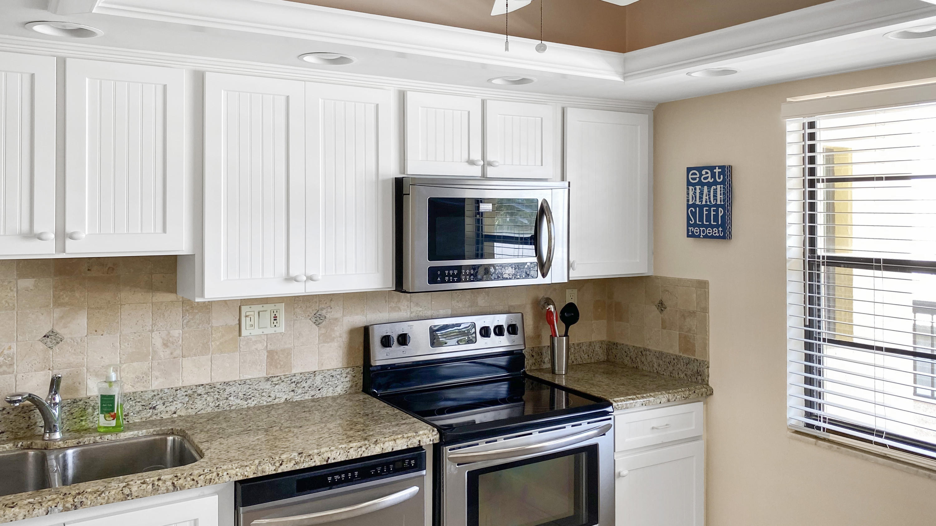 275 South Beach Road, Unit B202 Jupiter, FL 33469 - Photo 9 of 25 a kitchen with granite countertop a stove and a sink