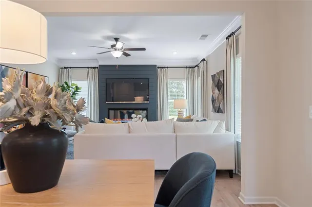 a living room with furniture a flat screen tv and a large window