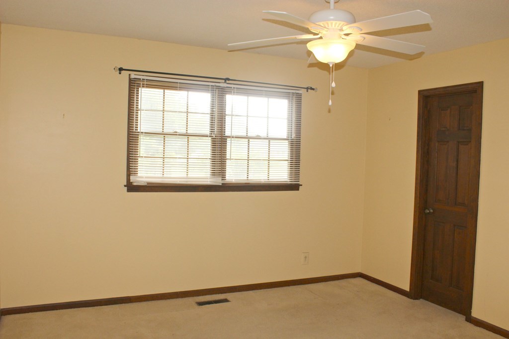 6231 Stapleton Road Macon, GA 31206 - Photo 8 of 12 an empty room with a window and a ceiling fan
