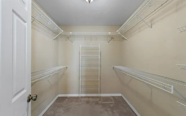 a view of walk in closet with empty racks
