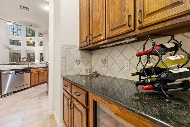 a kitchen with stainless steel appliances granite countertop wooden cabinets a stove top oven a sink and dishwasher