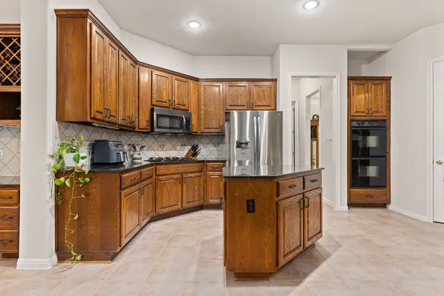 a kitchen with stainless steel appliances granite countertop a refrigerator and a stove