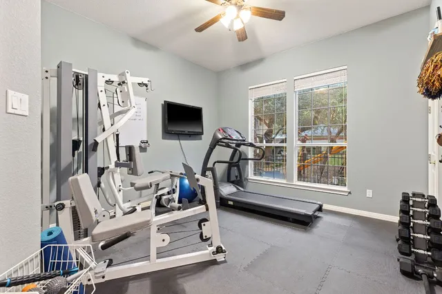 a living room with furniture gym equipment and a large window