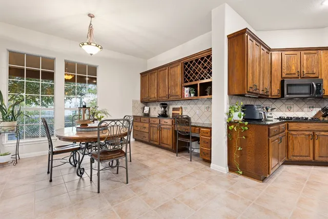 a kitchen with stainless steel appliances granite countertop a stove and more cabinets