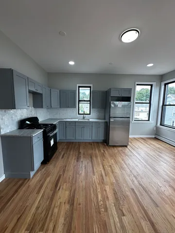 a kitchen with wooden floors and wooden cabinets