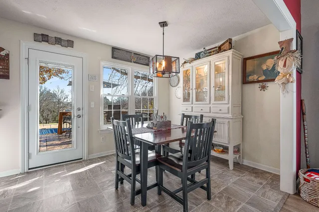 a dining room with furniture a chandelier and wooden floor
