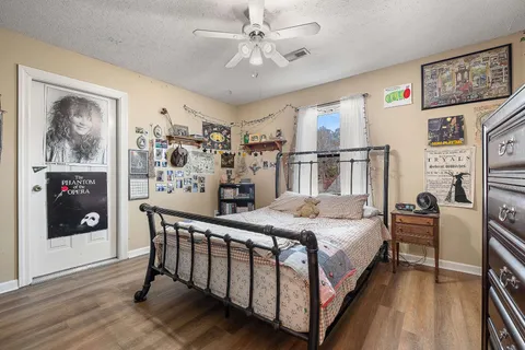 a bedroom with a bed a table and painting on the wall