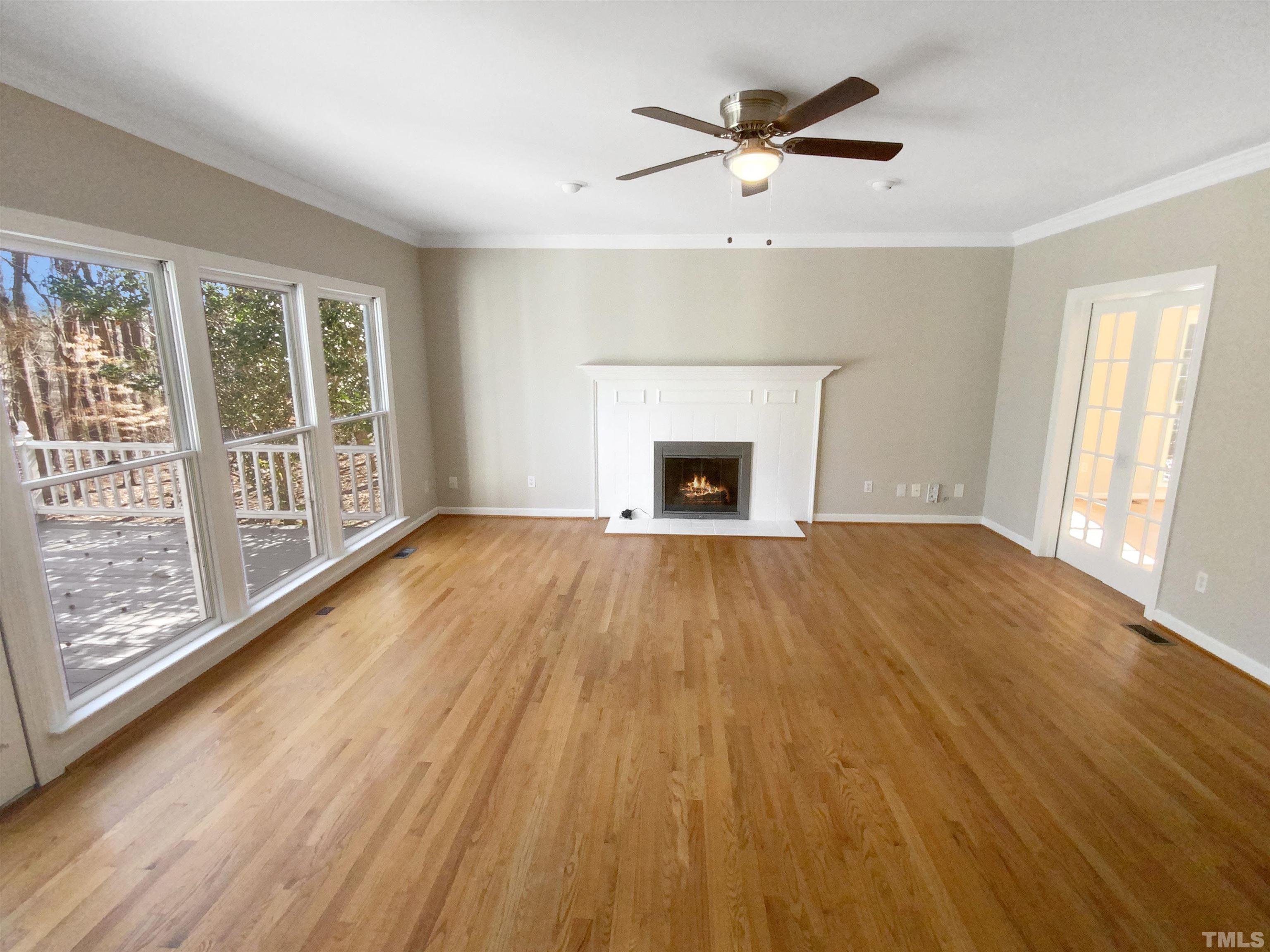 12020 Old Creedmoor Road Raleigh, NC 27613 - Photo 11 of 30 an empty room with wooden floor a ceiling fan and windows