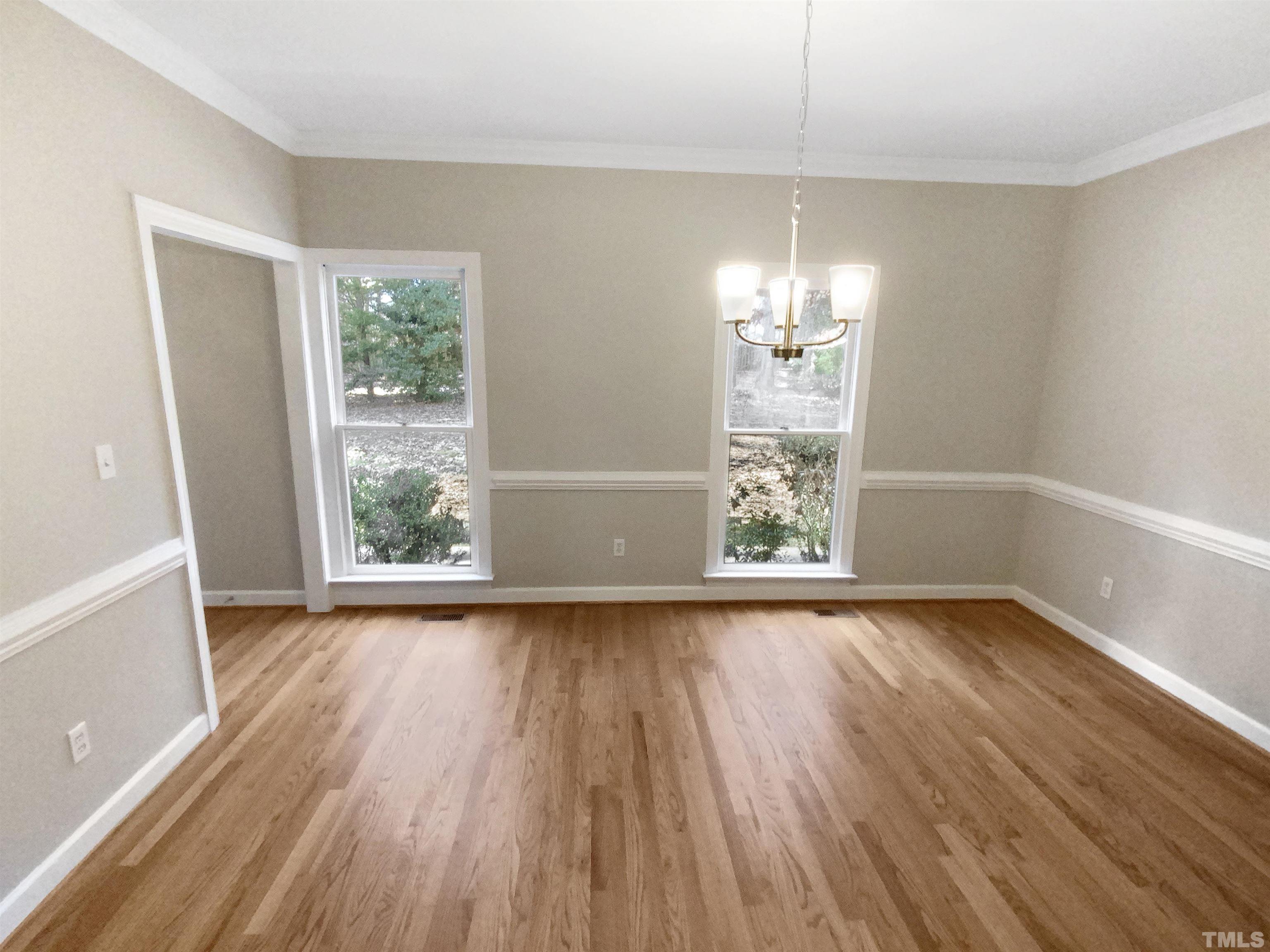 12020 Old Creedmoor Road Raleigh, NC 27613 - Photo 9 of 30 a view of an empty room with wooden floor and a window