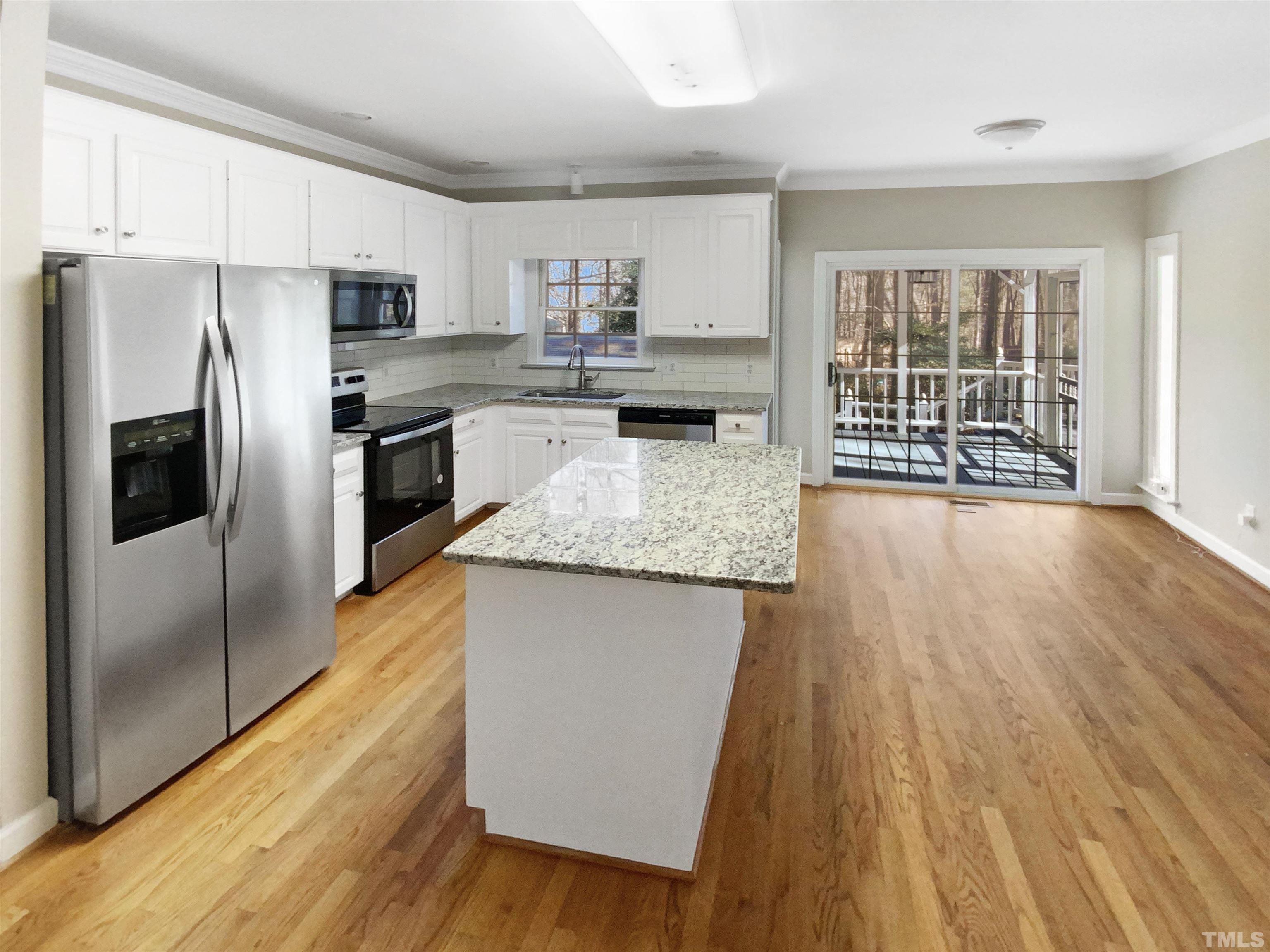 12020 Old Creedmoor Road Raleigh, NC 27613 - Photo 10 of 30 a kitchen with stainless steel appliances granite countertop a refrigerator a stove top oven a sink and dishwasher with wooden floor