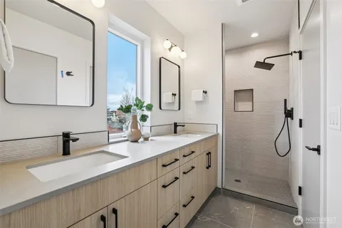 a bathroom with a double vanity sink and a mirror