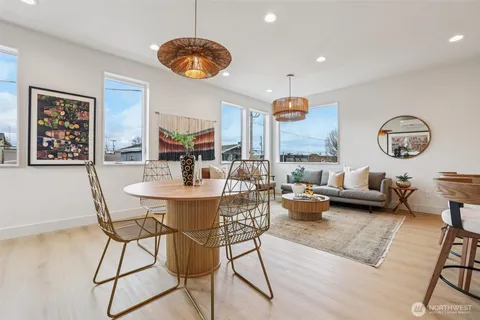 a view of a dining room and livingroom with furniture a rug a fireplace and a chandelier