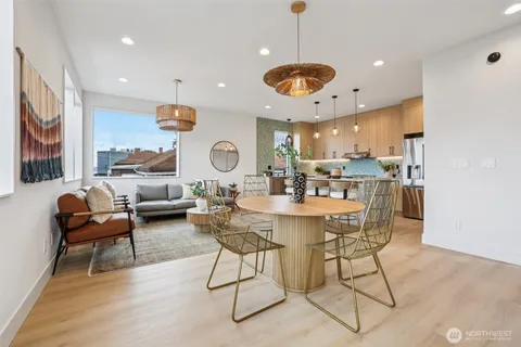 a kitchen with a dining table chairs stainless steel appliances and cabinets
