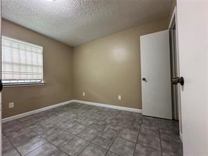 4607 East 12th Street, Unit 1 Austin, TX 78721 - Photo 8 of 9 Spare room with a textured ceiling and baseboards