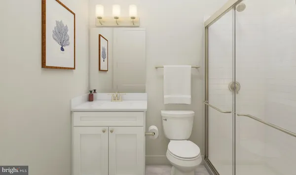 a bathroom with a granite countertop toilet sink and mirror
