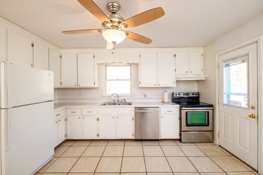 930 Claudius Court Crozet, VA 22932 - Photo 4 of 19 a kitchen with white cabinets a sink a stove a refrigerator and a window