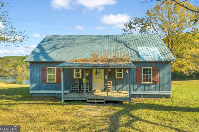 a view of a house with swimming pool and a porch with furniture