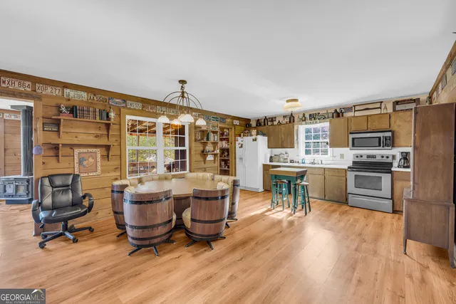 a dining room with furniture a chandelier and wooden floor
