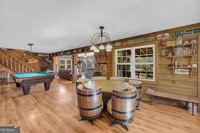 a dining room with furniture a chandelier and wooden floor
