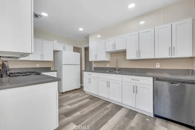 a kitchen with granite countertop white cabinets and white appliances