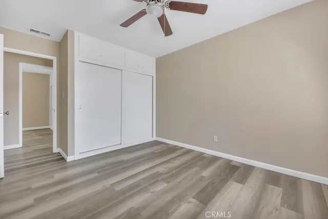 an empty room with windows and fan