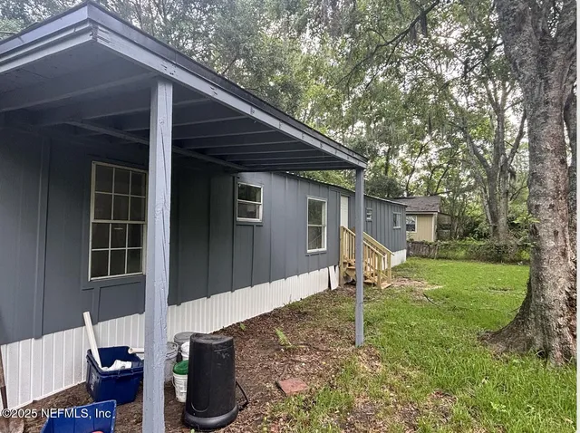 a backyard of a house with table and chairs