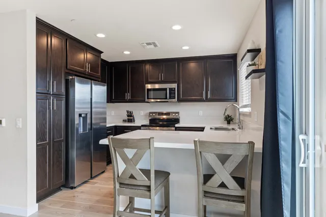 a kitchen with stainless steel appliances granite countertop a refrigerator stove microwave and sink