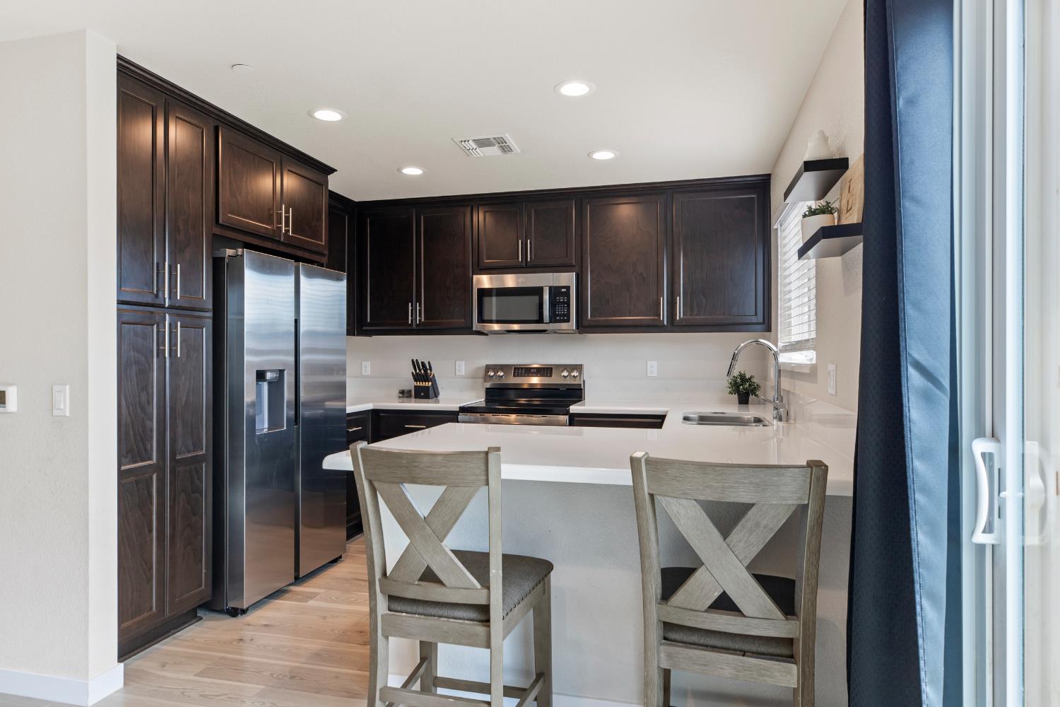 1202 Impression Street Turlock, CA 95380 - Photo 11 of 35 a kitchen with stainless steel appliances granite countertop a refrigerator stove microwave and sink