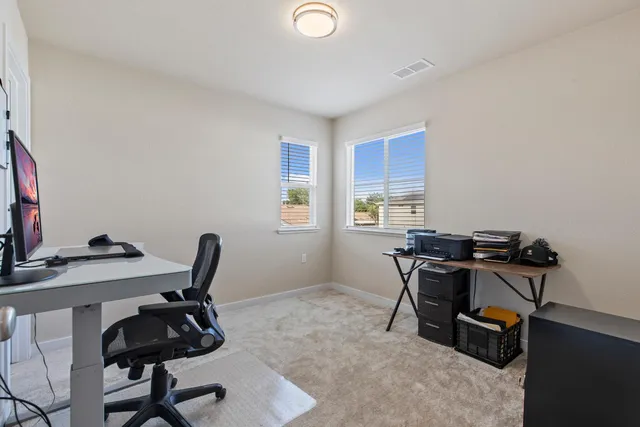 a view of a workspace with furniture and a window