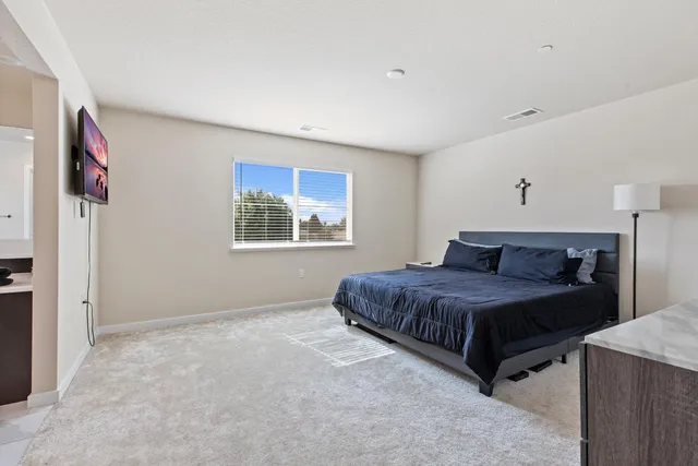 a bedroom with a bed and a painting on the wall