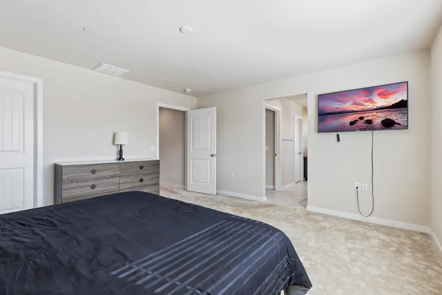 a bedroom with a bed and a view of kitchen