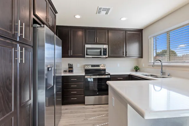 a kitchen with stainless steel appliances granite countertop wooden cabinets granite counter tops and a stove