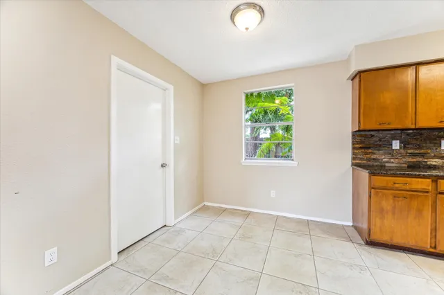 a view of kitchen with stainless steel appliances granite countertop a stove a sink and a window