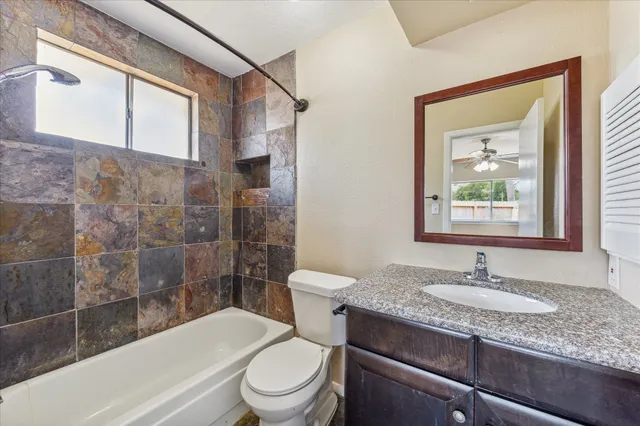 a bathroom with a granite countertop sink toilet and shower