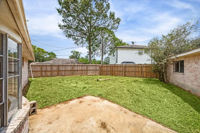 a view of backyard with wooden fence