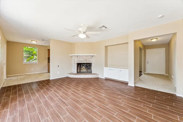 an empty room with windows and a fireplace