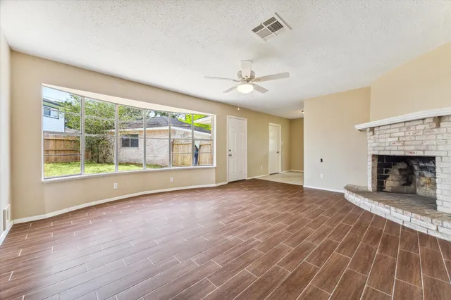 a view of an empty room with a fireplace and a window